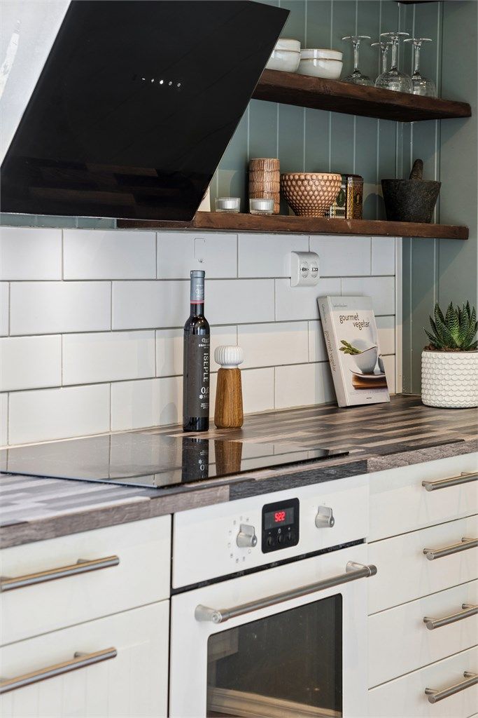 Kjøkkeninnredningen har en kombinasjon av glatte og profilerte fronter, laminert benkeplate og integrert stekeovn og platetopp.