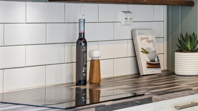 Kjøkkeninnredningen har en kombinasjon av glatte og profilerte fronter, laminert benkeplate og integrert stekeovn og platetopp.