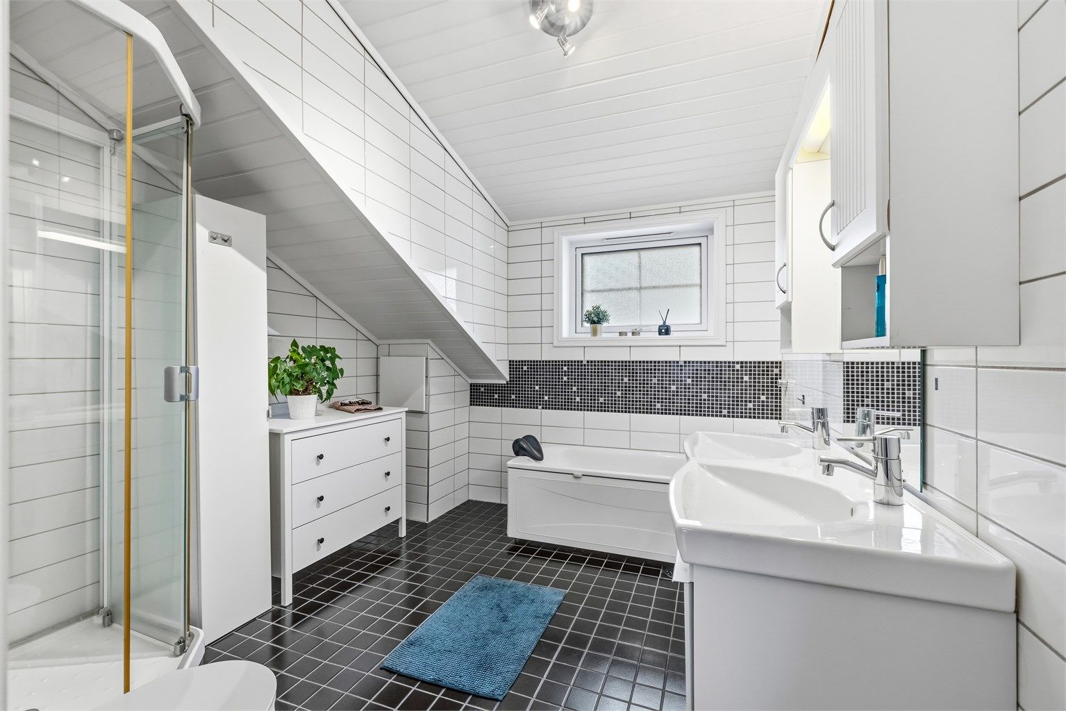 Badet i loftsetasjen byr på både et frittstående badekar og et separat dusjkabinett.
