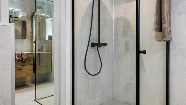 Dør inn til vaskerom med speil i front. Pene og moderne detaljer på utstyr og møblement.