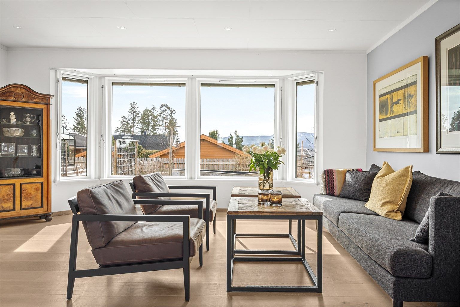 Store vindusflater, hvorav flere er av nyere dato, gir rikelig med dagslys inn i stuen.