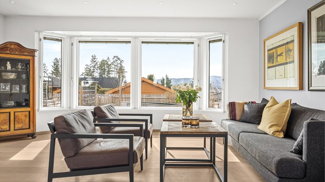 Store vindusflater, hvorav flere er av nyere dato, gir rikelig med dagslys inn i stuen.