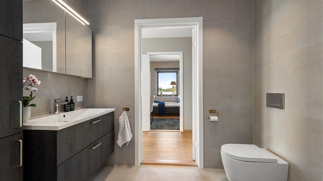 Badet har vegghengt toalett og et romslig dusjhjørne med både regn- og hånddusj