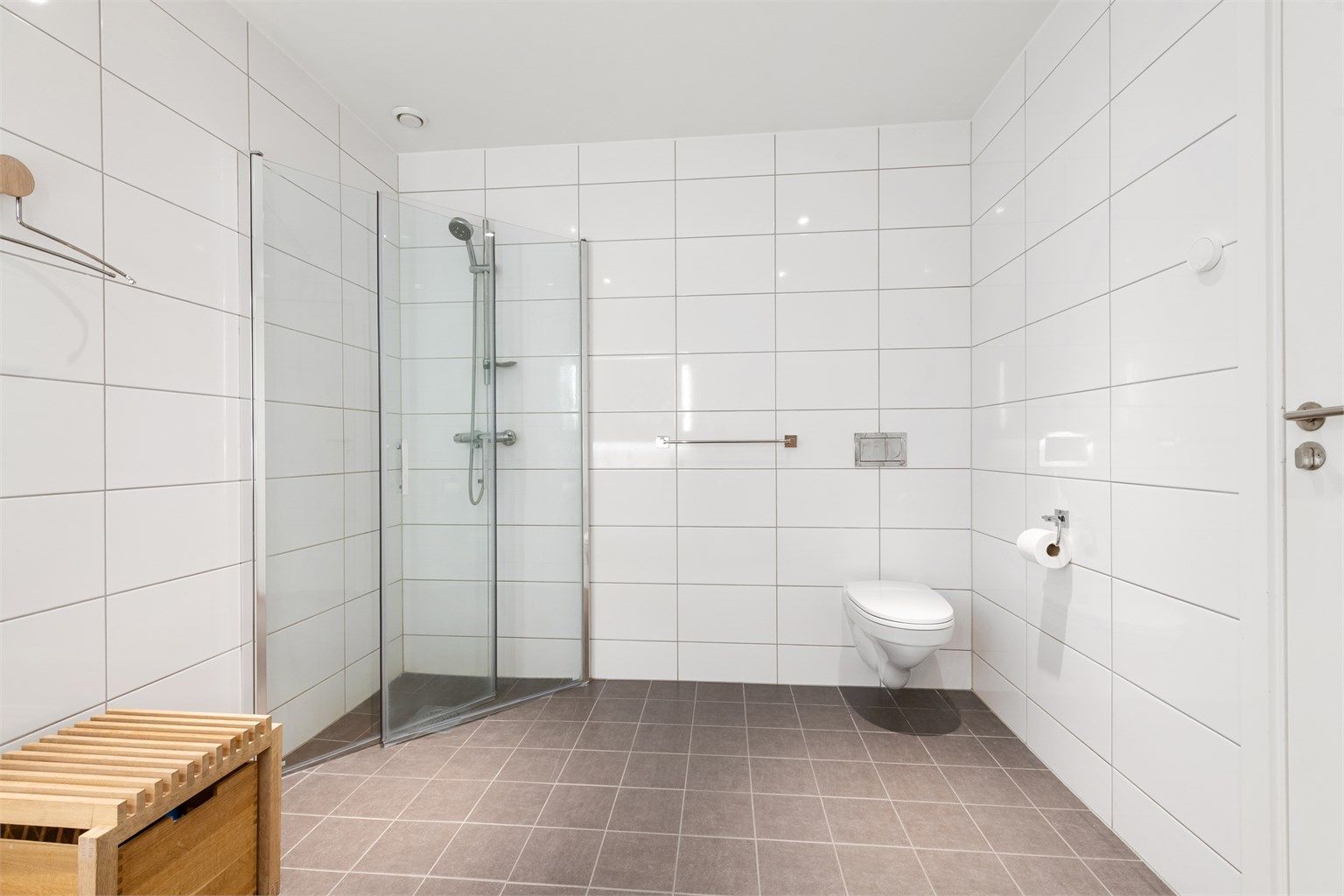 Dusjhjørne med foldbare glassvegger og vegghengt toalett