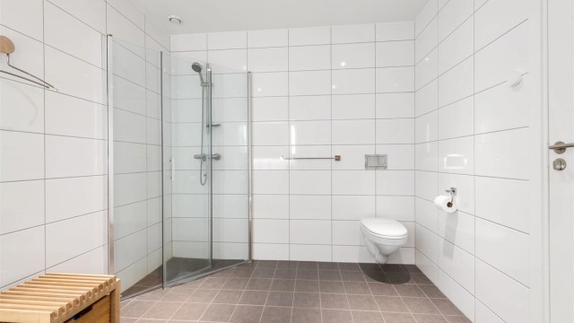 Dusjhjørne med foldbare glassvegger og vegghengt toalett