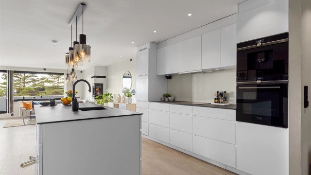 Kjøkkenet er velutstyrt med integrerte hvitevarer som kaffemaskin og stekeovn, platetopp, kjøleskap og oppvaskmaskin