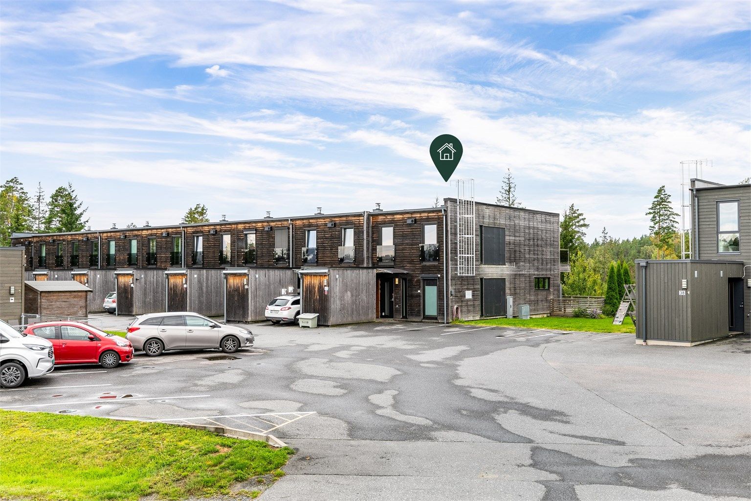 Denne boligen har en attraktiv plassering i husrekkens nordre ende, med biloppstillingsplass rett utenfor. Lader er montert på husveggen.