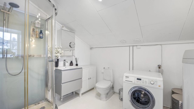 Badet i hyblen er utstyrt med dusjkabinett, toalett og servantinnredning. Det er varmekabler i deler av gulvet.