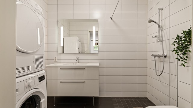 Kombinert bad og vaskerom i underetasjen med opplegg for vaskemaskin og tørketrommel.
