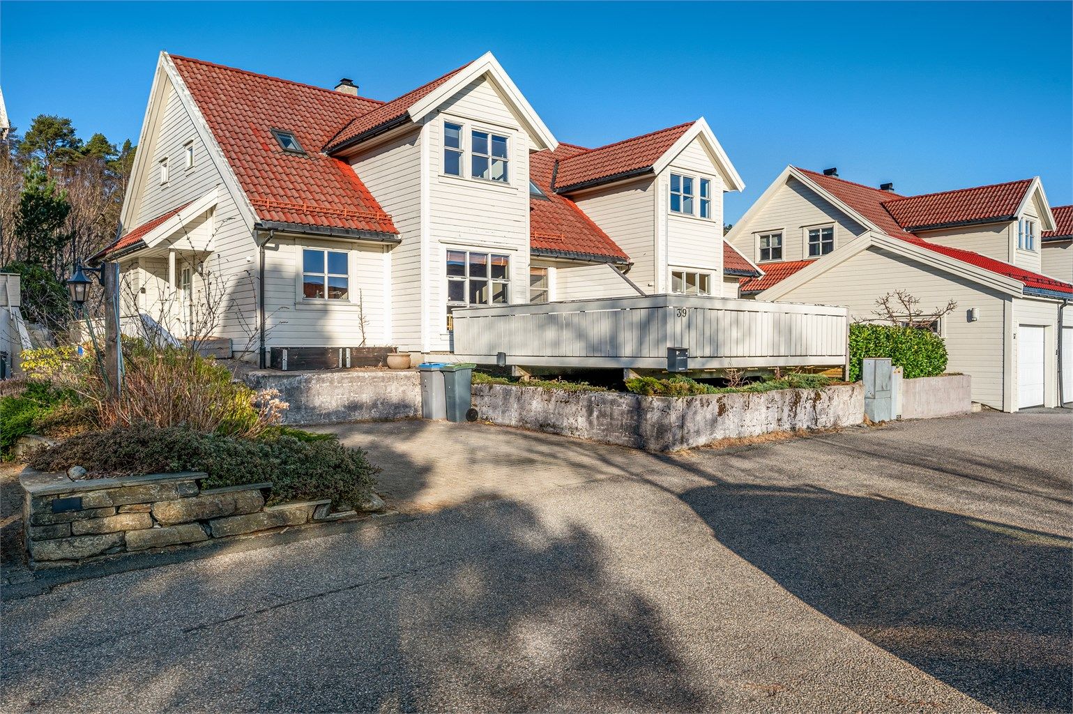 Rett utenfor inngangspartiet har man en planert og romslig biloppstillingsplass med el-bil lader.