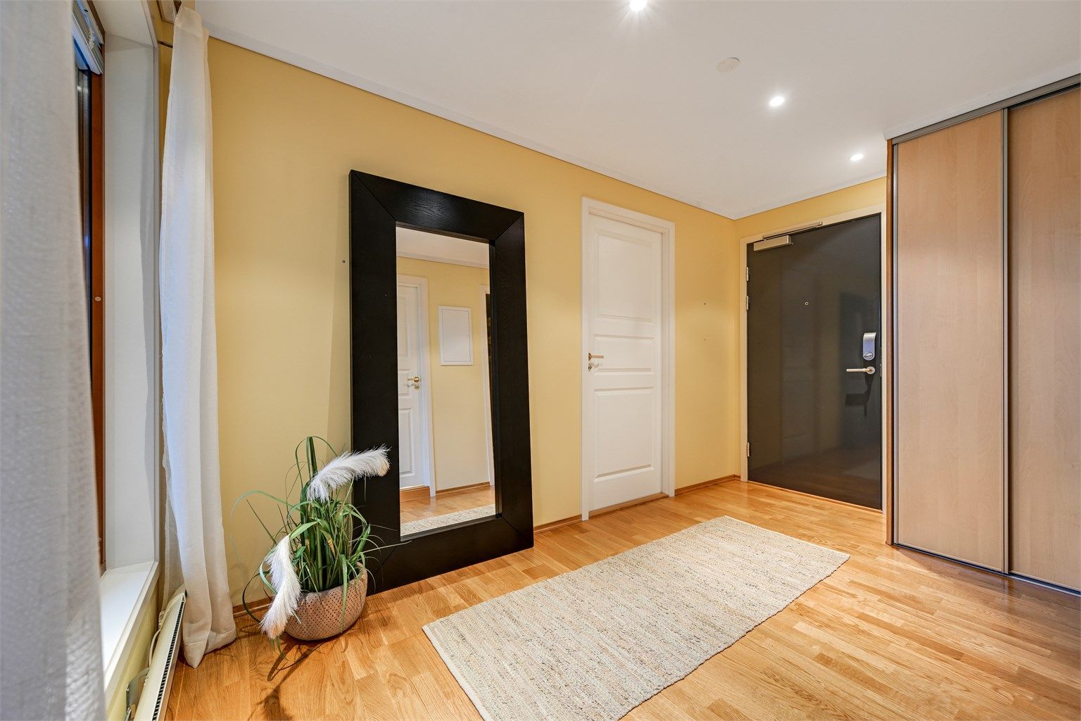 Leiligheten har en romslig entrè og det er mulig å ta heis opp til 2. etg.