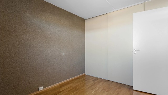 Rommet har innebygget skyvedørsgarderobe i glatt utførelse.