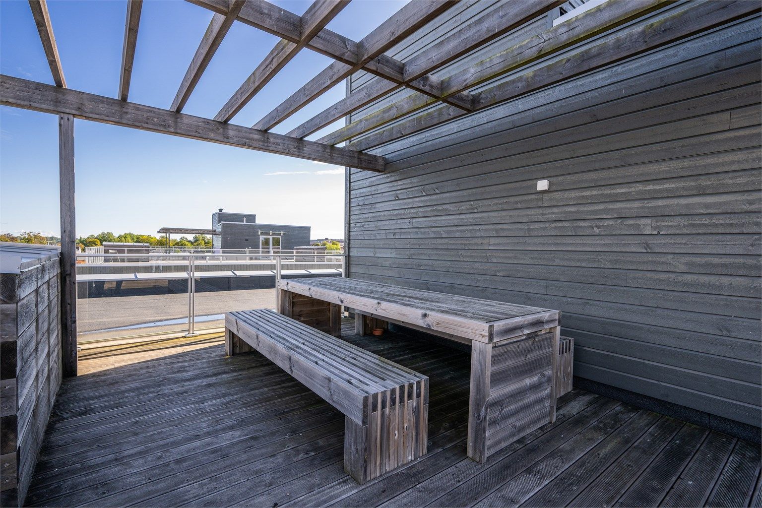 Skjermet sittegruppe under pergola på takterrassen.