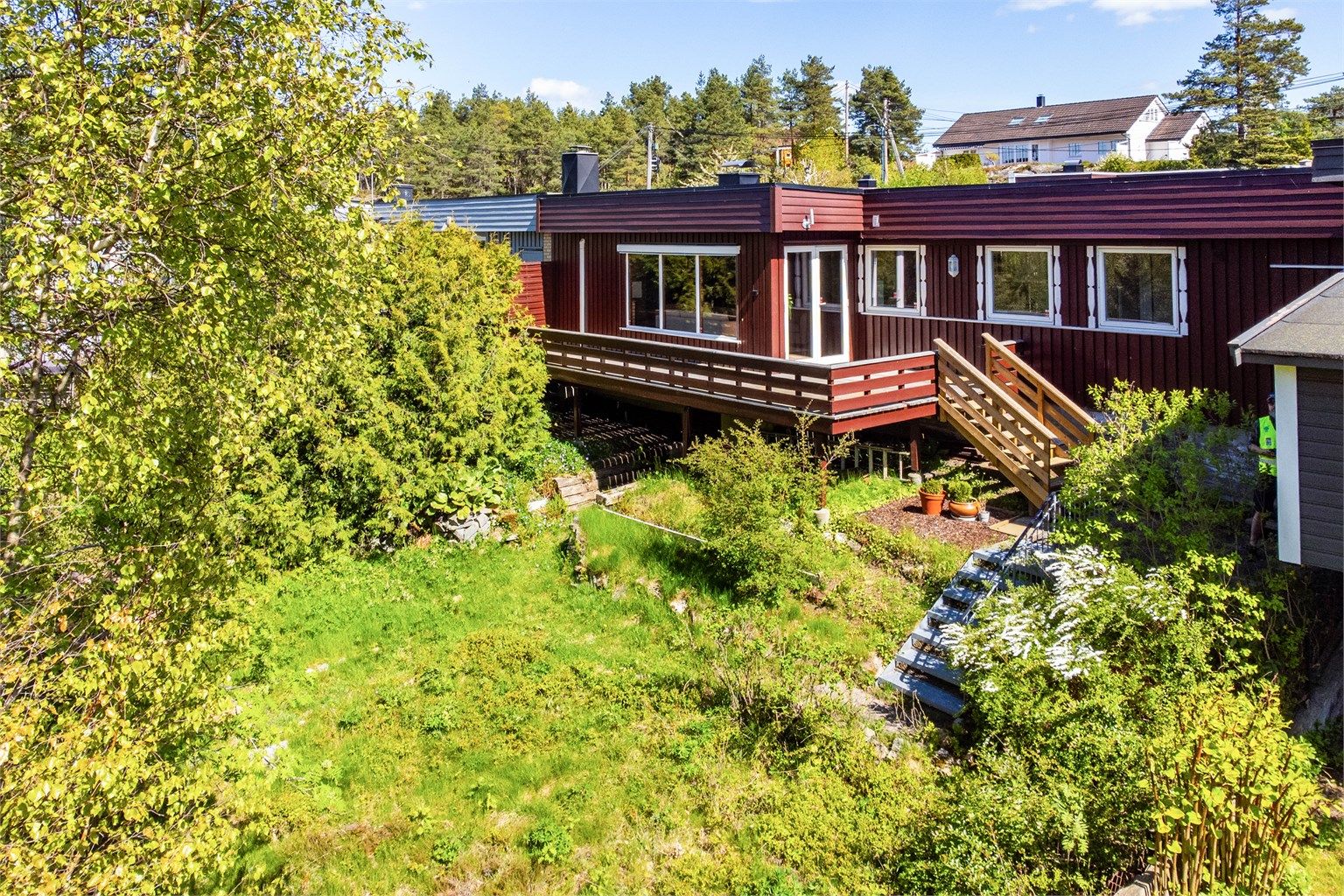 Vestsiden av tomtens 434 kvm. er i stor grad naturlig terreng, men solfylt og har flere muligheter - kanskje en kjøkkenhage?