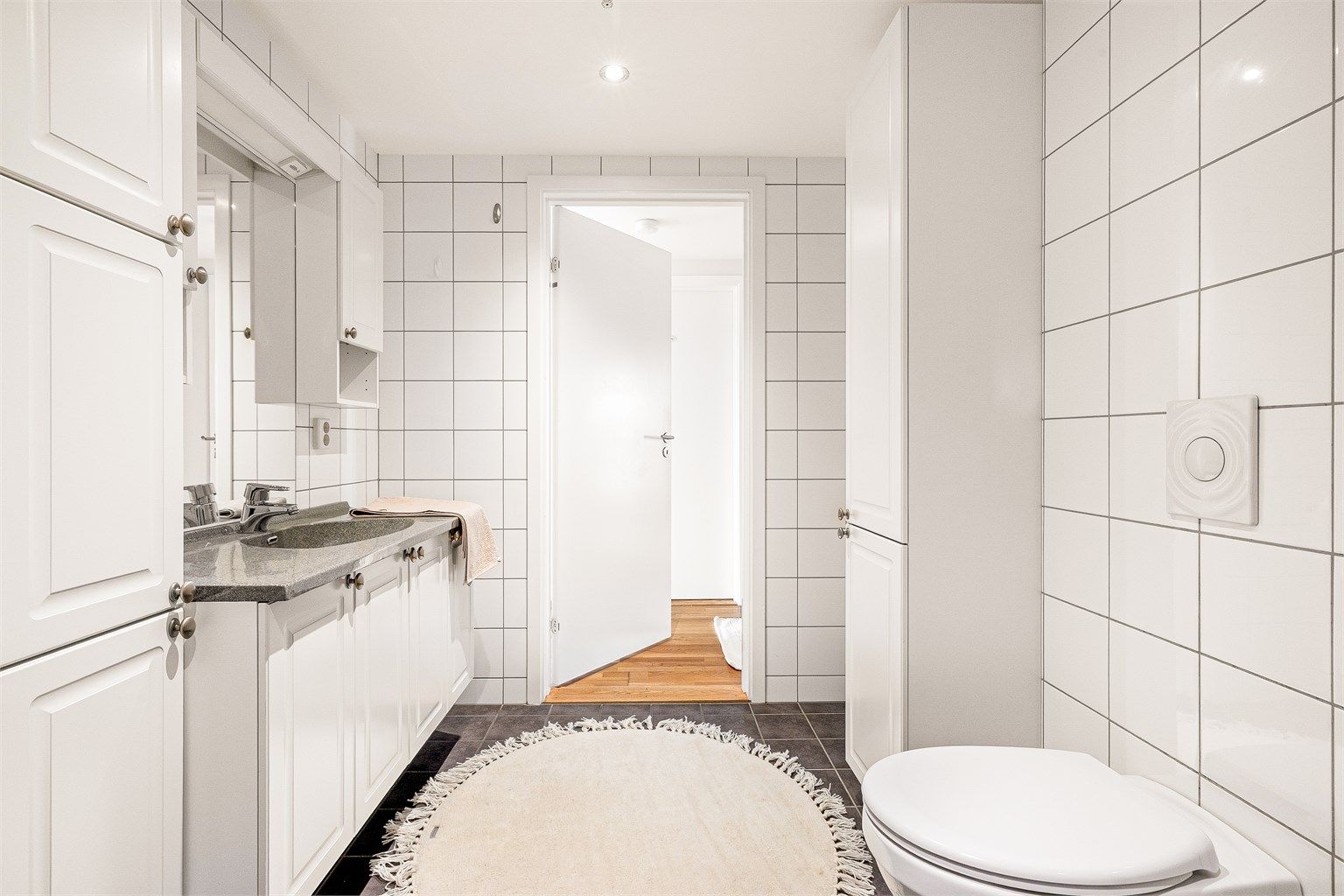 Badet er praktisk innredet med rikelig skapplass og opplegg for vaskemaskin.