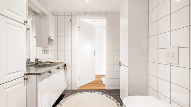 Badet er praktisk innredet med rikelig skapplass og opplegg for vaskemaskin.