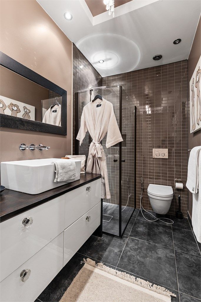 Dusjhjørne med dører. Vegghengt dusjarmatur (hånddusj og regndusj). Vegghengt toalett.