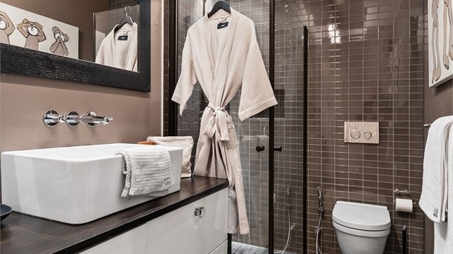 Dusjhjørne med dører. Vegghengt dusjarmatur (hånddusj og regndusj). Vegghengt toalett.