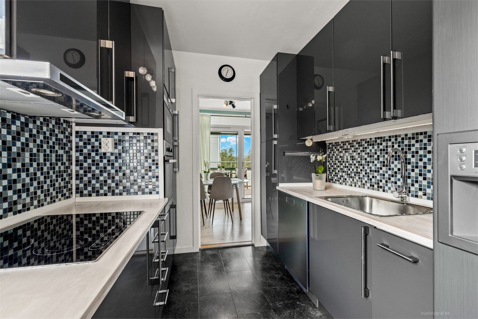 Moderne og stilren kjøkkeninnredning med godt utnyttet skap- og benkeplass. Foto: Haiman Askari/Knipzet AS