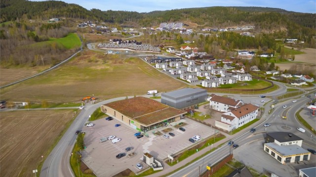 Stor Kiwi butikk på flata på vei opp til boligfeltet. Rett ved Kiwi ligger også en Padelhall.