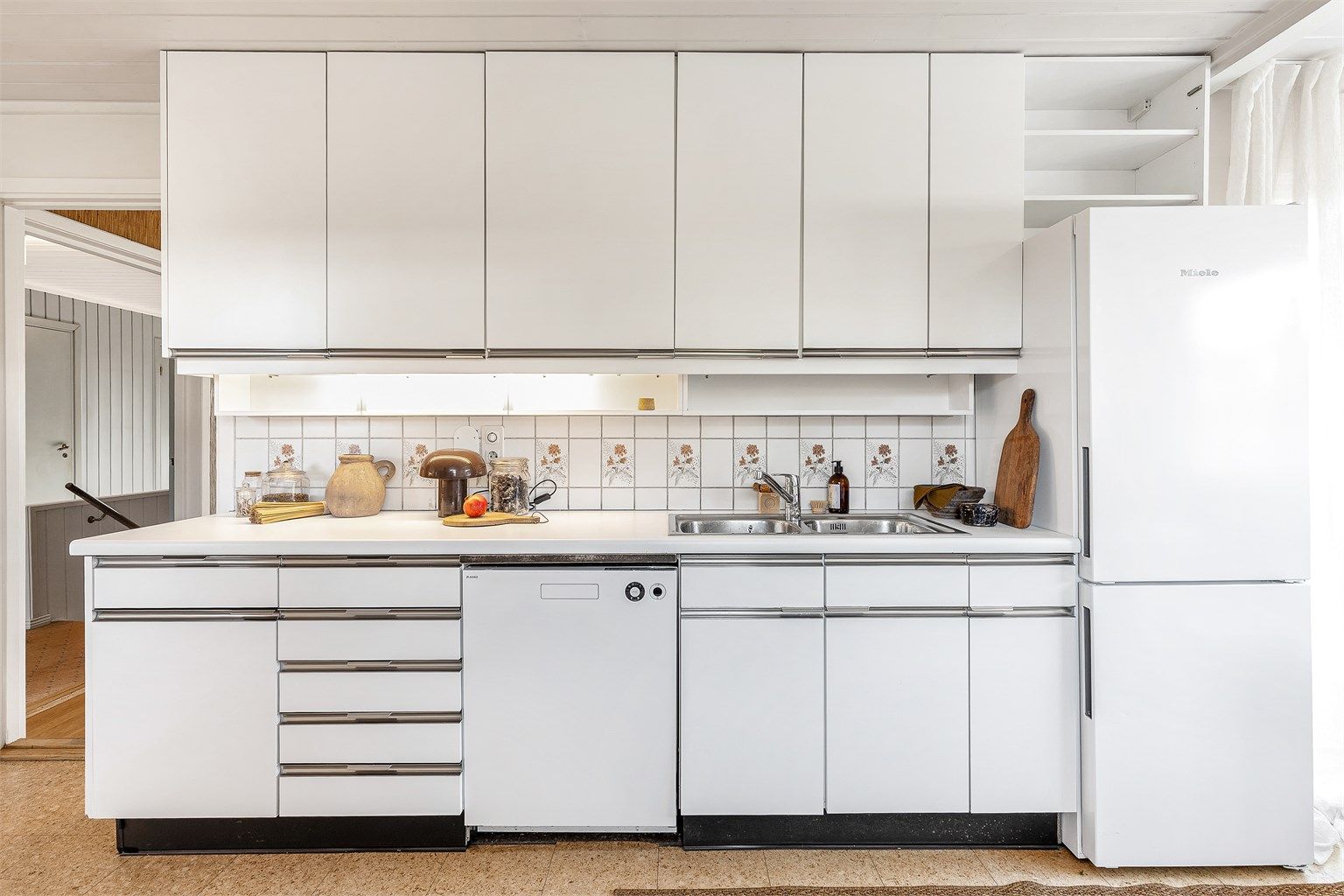 Benkeplate er av laminat og frittstående kjøleskap og oppvaskmaskin.
