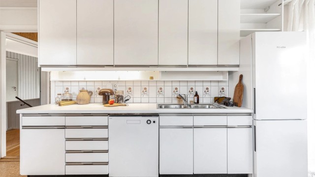 Benkeplate er av laminat og frittstående kjøleskap og oppvaskmaskin.