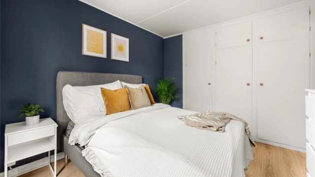 Soverommet har rikelig med oppbevaringsplass. I tillegg til plassbygde skap skjuler det seg et walk-in closet bak skapdøren til venstre.