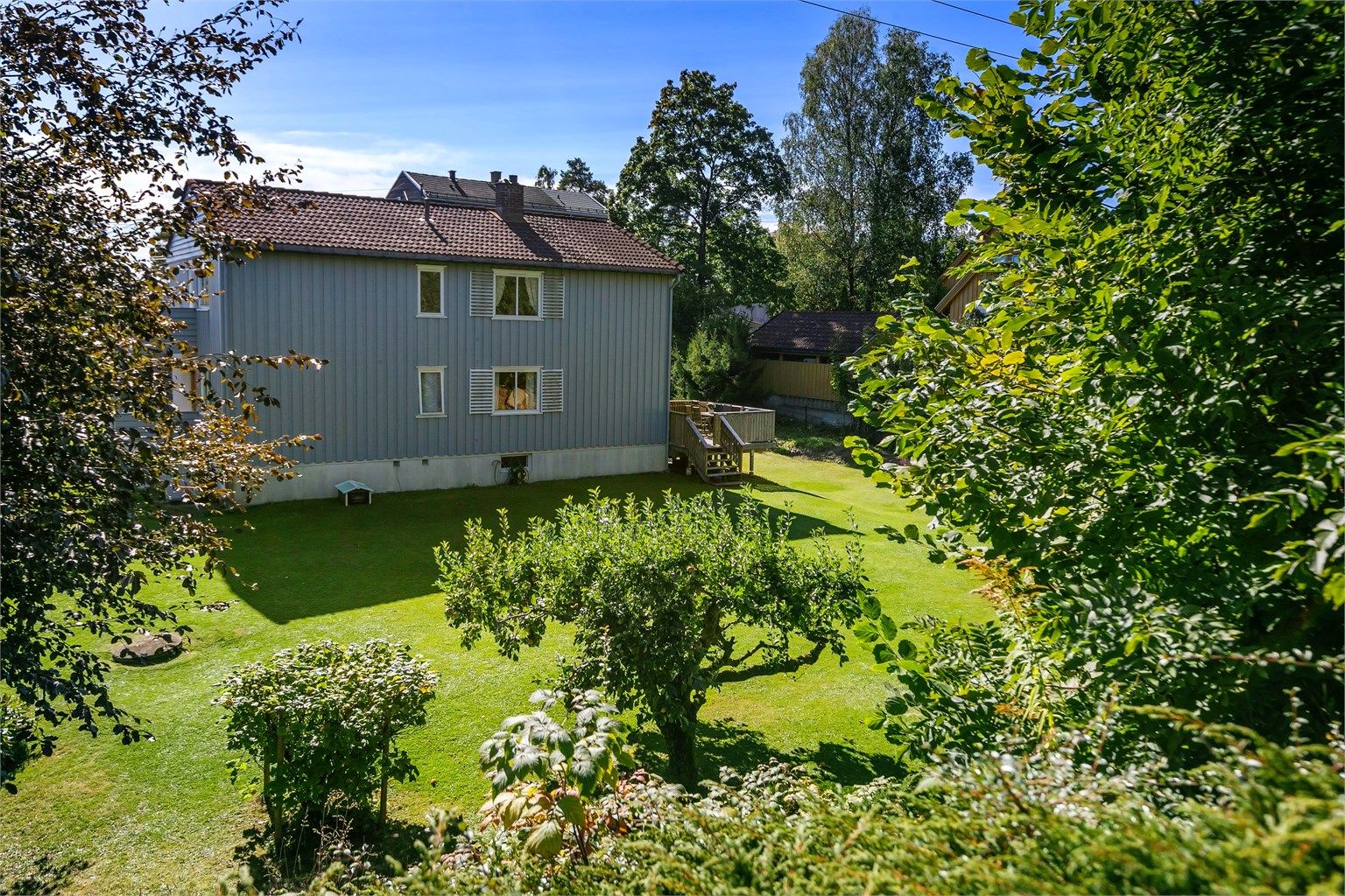 Eiendommen er opparbeidet med store plenarealer, trær og beplantning.
Foto: Zovenfra