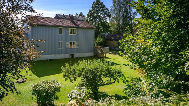 Eiendommen er opparbeidet med store plenarealer, trær og beplantning.
Foto: Zovenfra