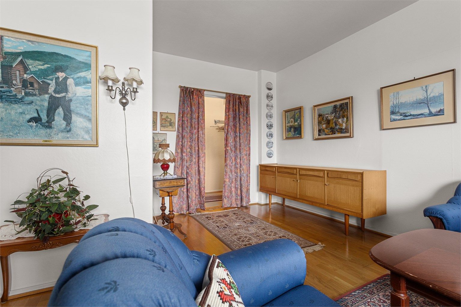 Rommet har parkett på gulv og lyse overflater. 