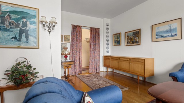 Rommet har parkett på gulv og lyse overflater.