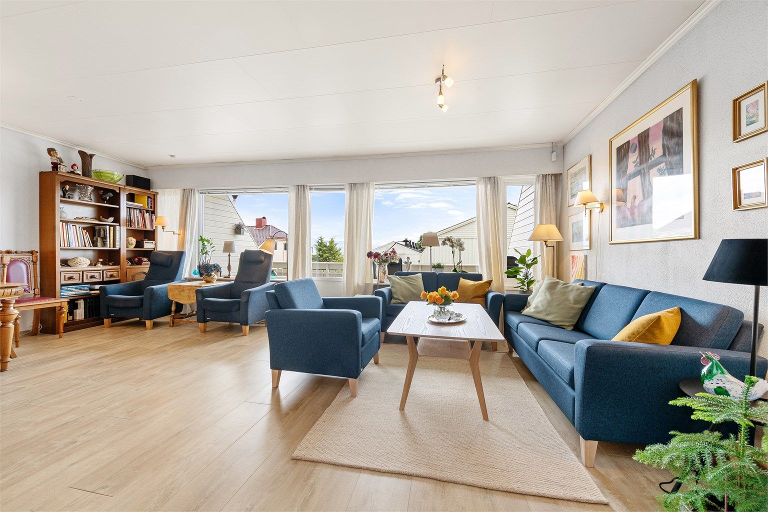 Store vindusflater i stuen gir rikelig med dagslys og en åpen atmosfære.