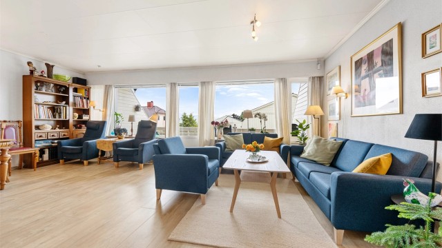 Store vindusflater i stuen gir rikelig med dagslys og en åpen atmosfære.