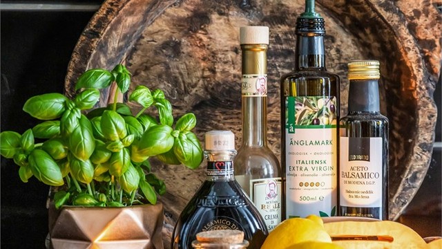 Mørke flislagte veggflater over kjøkkenbenken med benkeskapsbelysning.