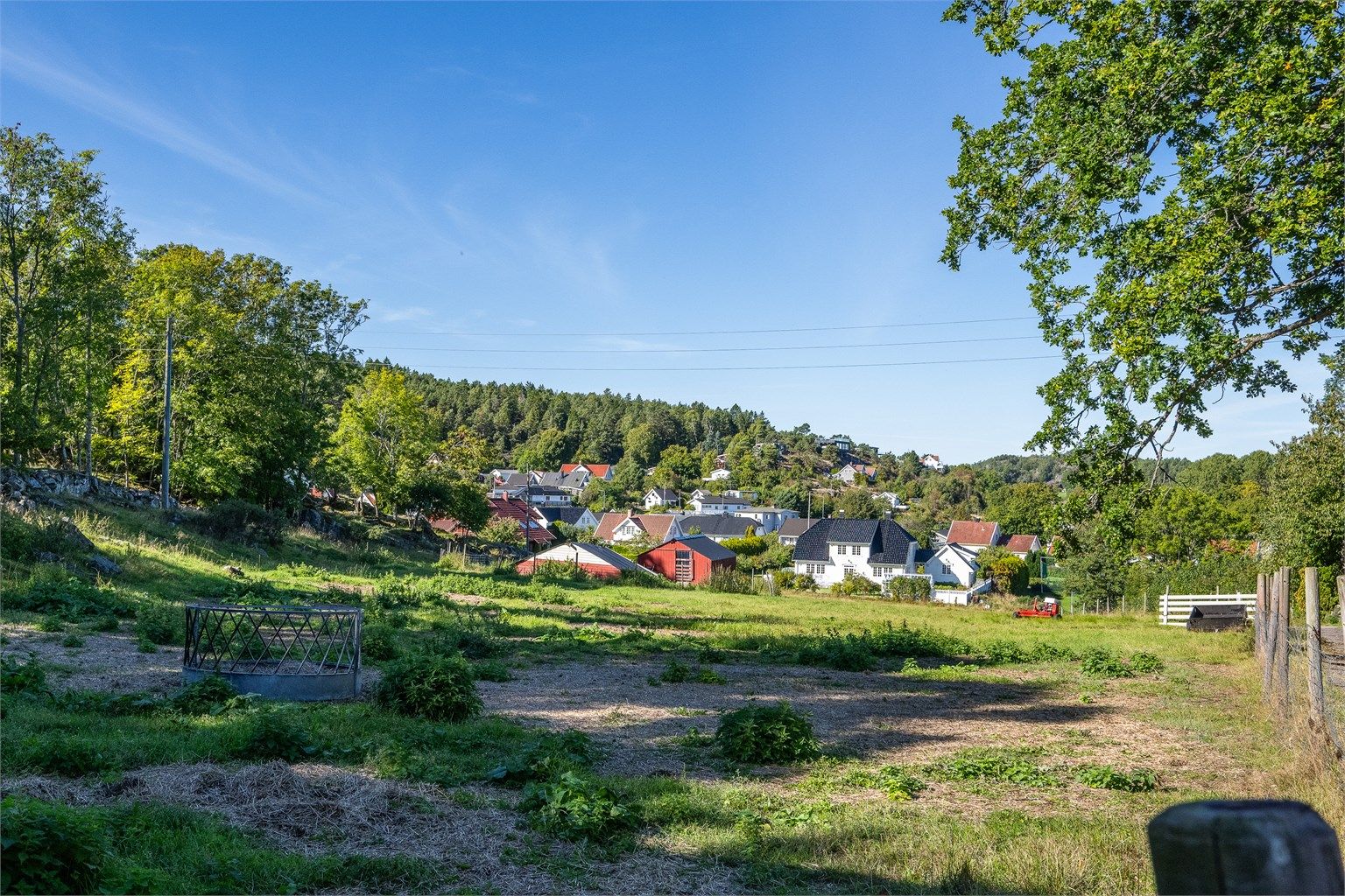 Utsyn over de grønne engene og det omkringliggende nabolaget på Grimestad. 