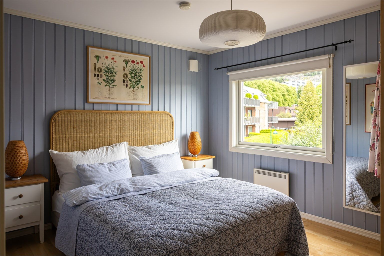 Hovedsoverommet har en lun fargepalett og grønt utsyn mot Grefsenåsen