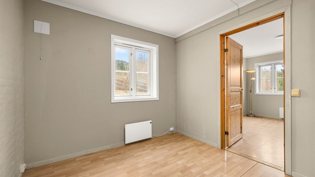 Lyst soverom på 8,5 kvm i utleiedelen med plass til seng, nattbord og garderobeskap.