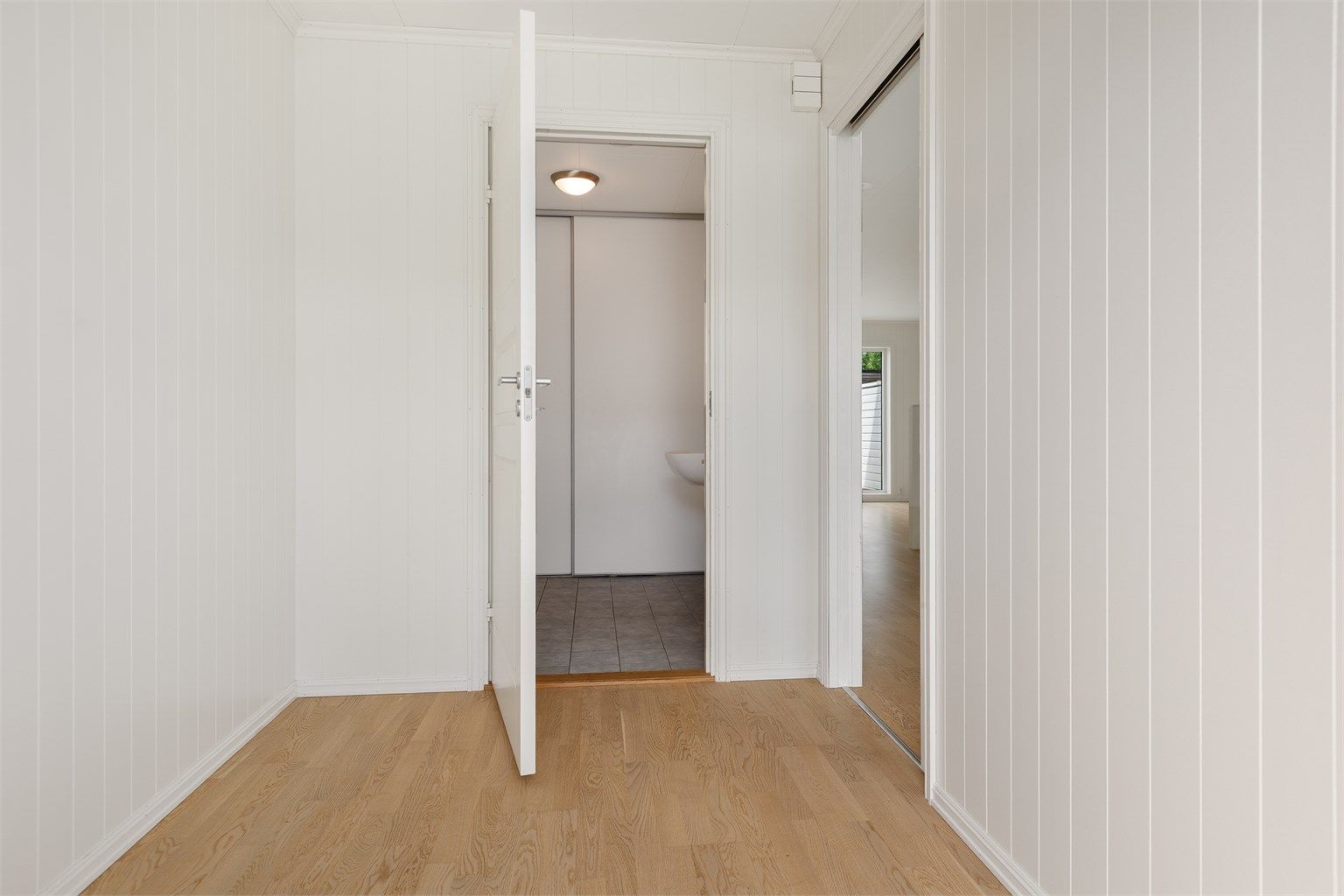 Entreen har dør inn til vaskerom med toalett, og skyvedør inn til kjøkken