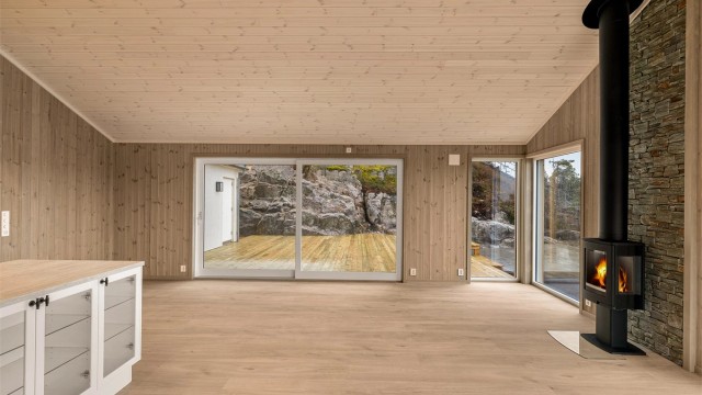 I stua kan du nyte både varmen fra peisovnen og utsikten ut over Trosbyfjorden. Vedovnen er fra den norske produsenten Nordpeis.
