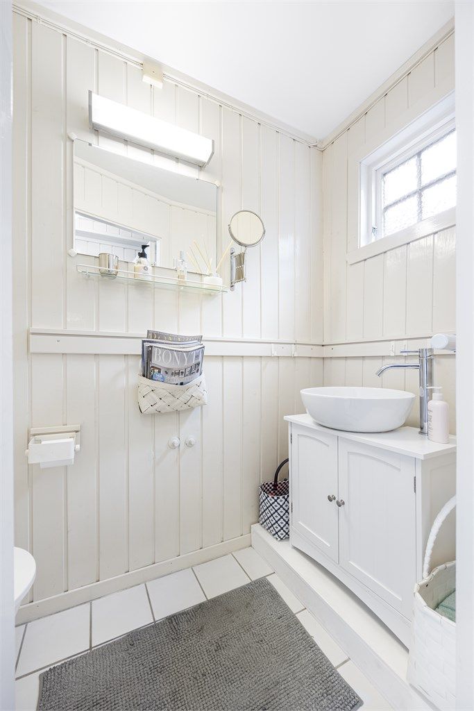 Praktisk toalettrom i hovedetasjen med flislagt gulv og nyere servantinnredning.