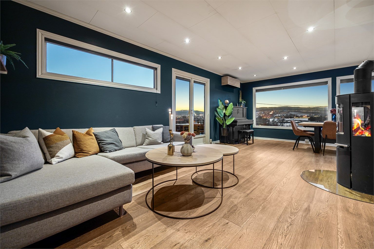 Stuen er et lunt samlingspunkt med peis (pipe bør rehabiliteres), parkett på gulv og store vindusflater.