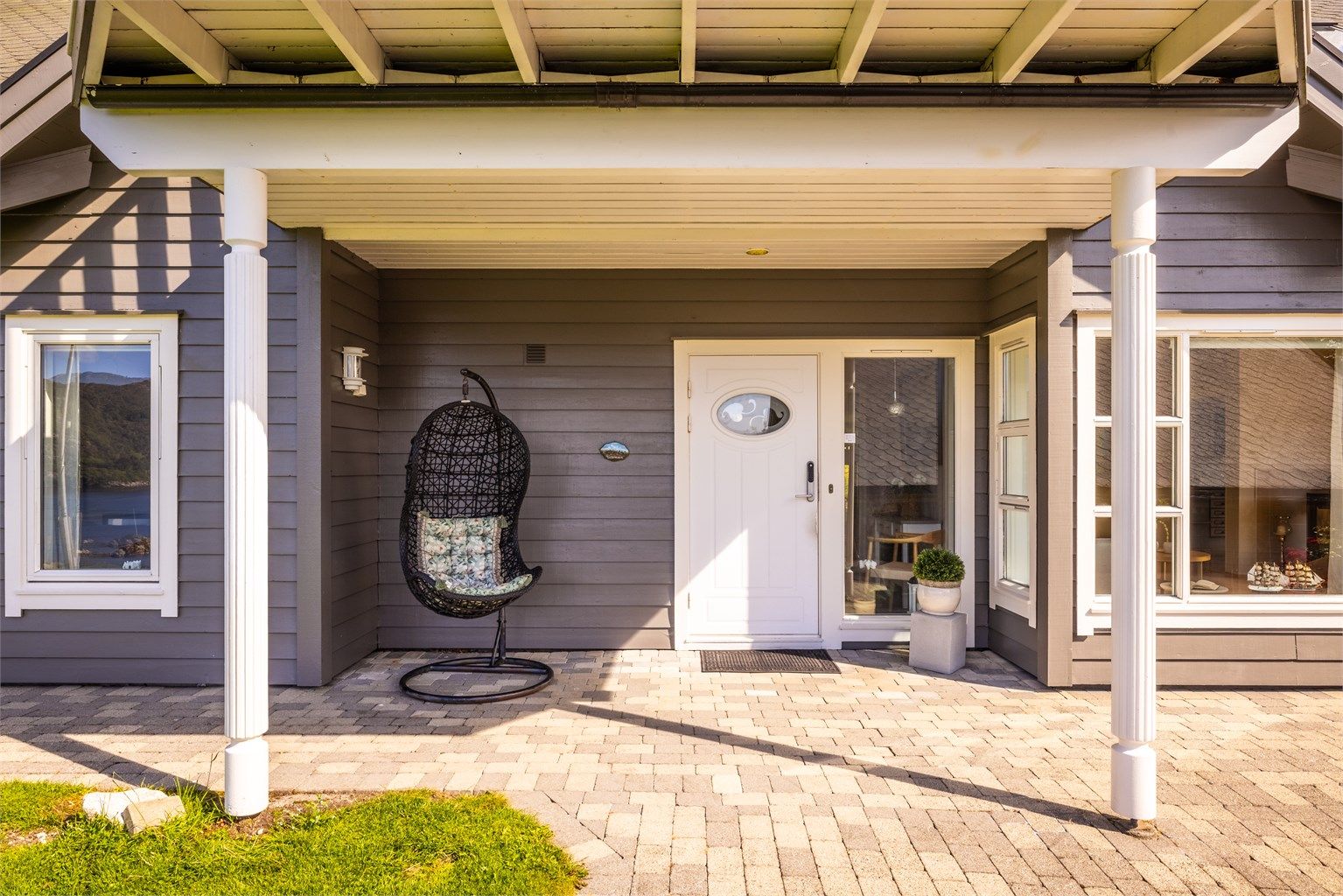 Overbygget inngangsparti. Legg også merke til lekre detaljer som de profilerte søylene og downlights i inngangspartiet. Lekre detaljer og smarte løsninger er gjennomgående i huset.