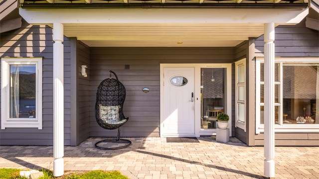 Overbygget inngangsparti. Legg også merke til lekre detaljer som de profilerte søylene og downlights i inngangspartiet. Lekre detaljer og smarte løsninger er gjennomgående i huset.