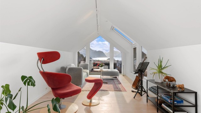 Gulv i loftstuen har en-stavs laminat og lyse malte tak og vegger med listefrie overganger