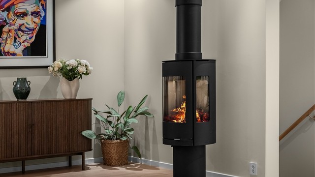 Moderne, frittstående peisovn med sideglass som gir godt innsyn til flammene.