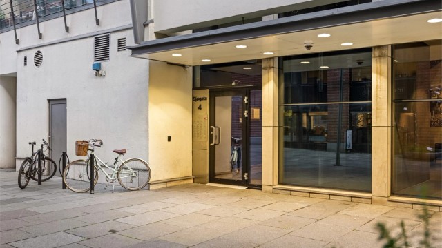 Representativt inngangsparti i Sjøgata med overbygg og tilhørende sykkelparkering.