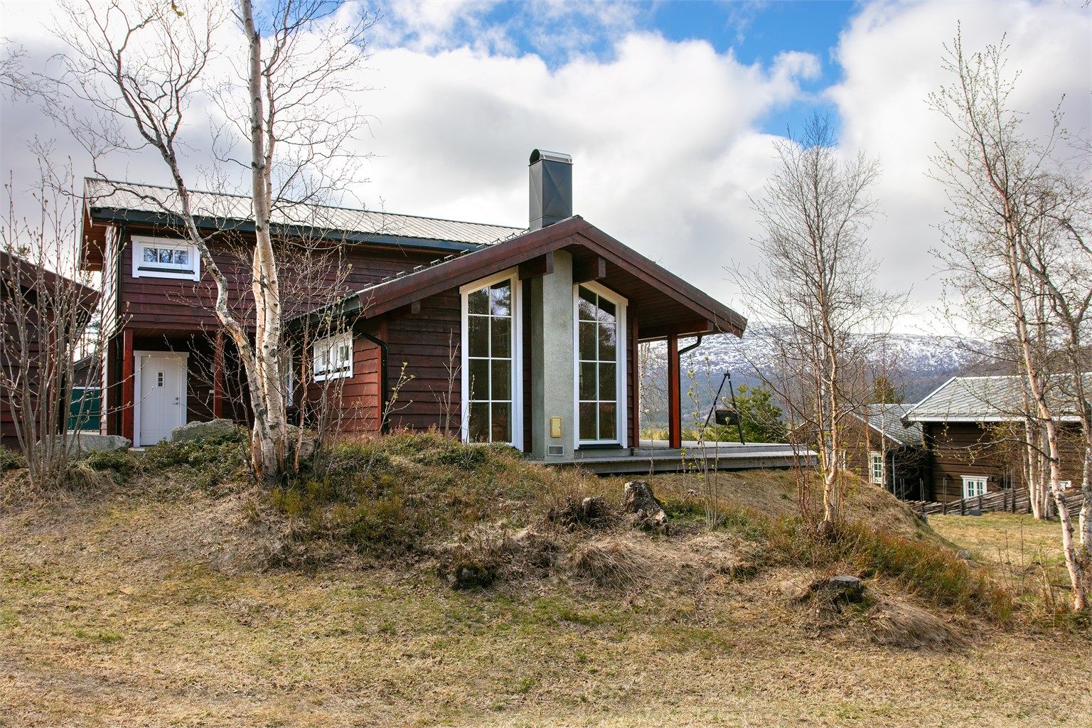 Fasaden mot vest har store vinduer som slipper inn mye naturlig lys i stuen.