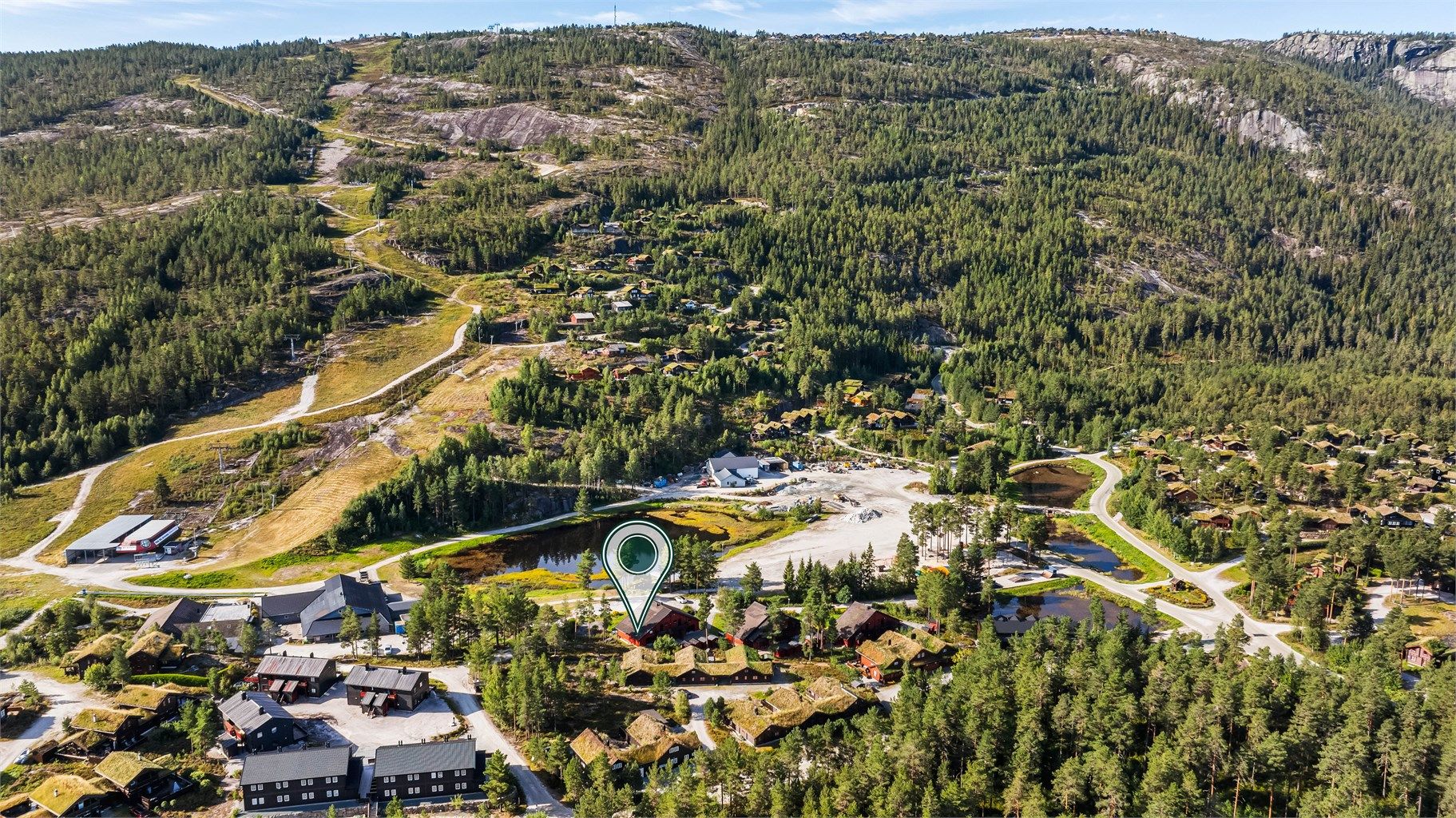 Eiendommen ligger på en felleseiet selveiertomt som deles mellom tre hytter i rekke. Hytten er en endeseksjon og har derfor en mer usjenert beliggenhet enn de øvrige.