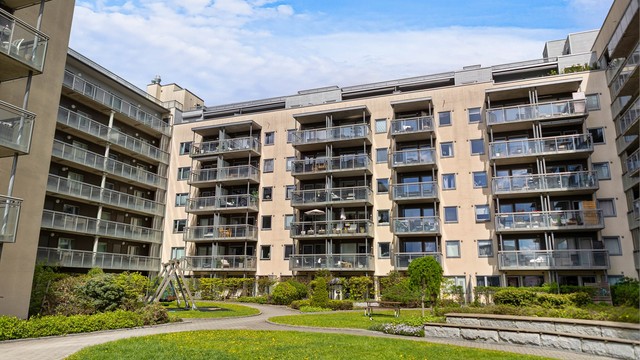 Pent opparbeidet og skjermet gårdsrom med lekeplass og grøntarealer for beboerne.