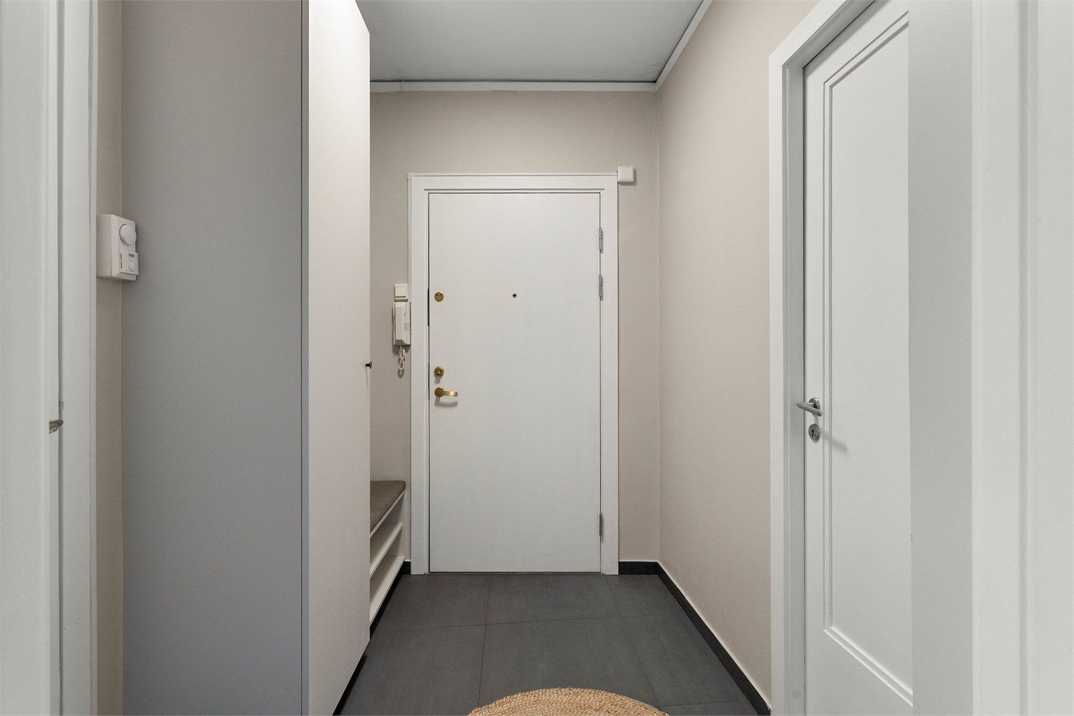 Velkommen inn! Entréen har plassbygde garderobeløsninger og sittebenk utført av Aas Møbeldesign i 2023.